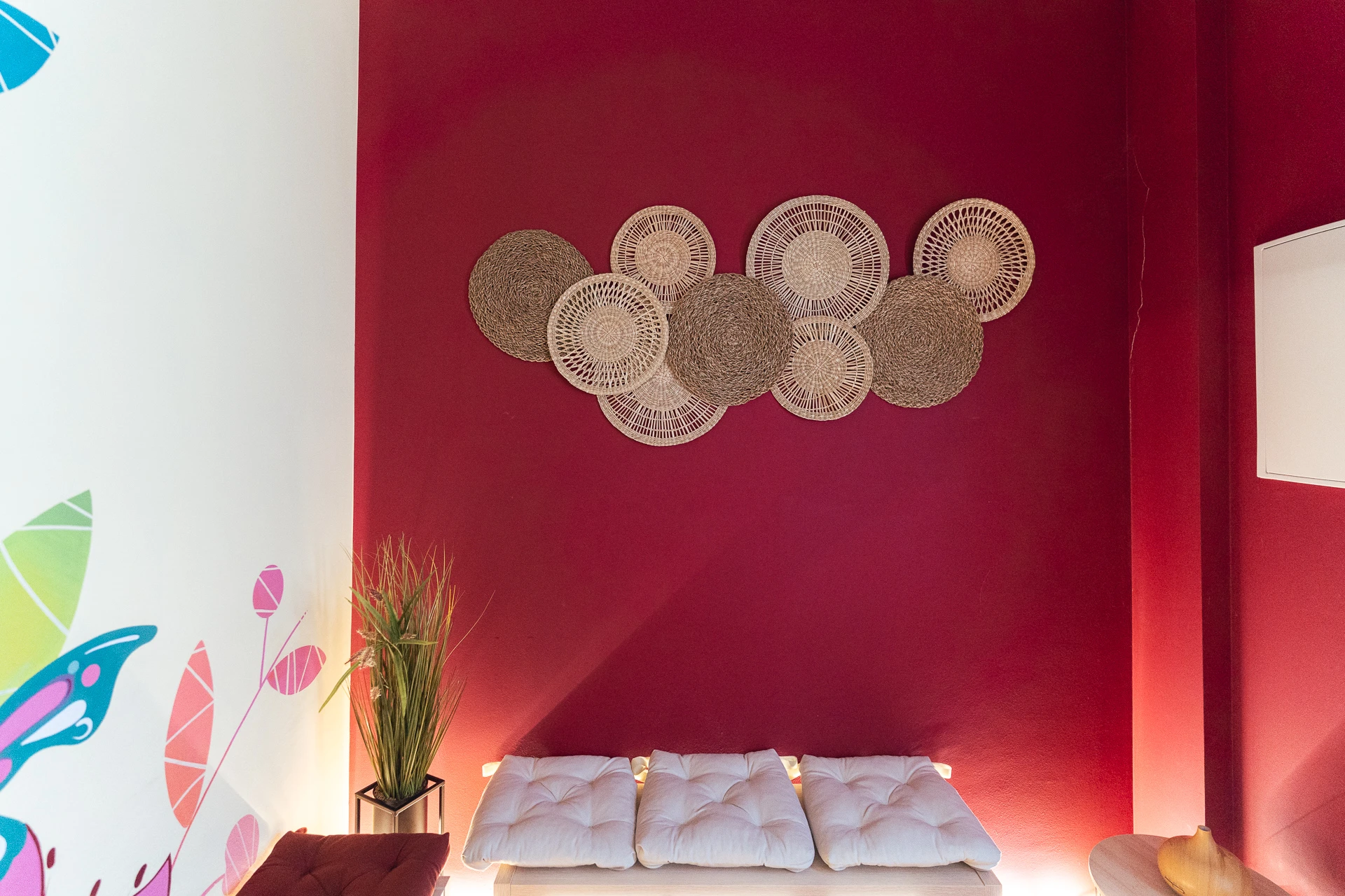 Entrada de EstelFisiosalut con decoración colorida, bonitos detalles en la pared y asientos cómodos.