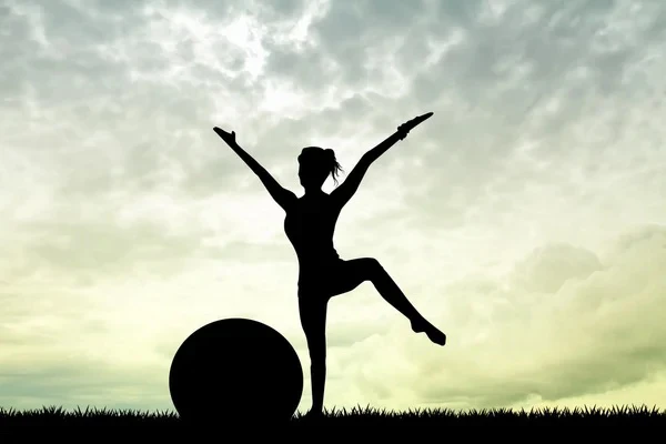Mujer de L'Alcúdia haciendo pilates con una pelota a contraluz en la naturaleza.